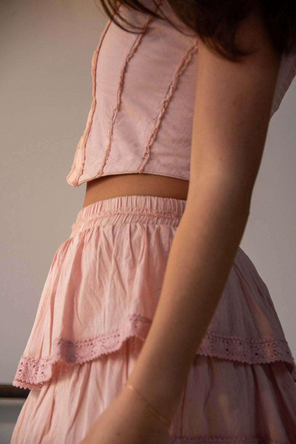 Detalle del top rosa palo con falda corta de olanes y encaje calado — campaña Collabs, Amor Amore