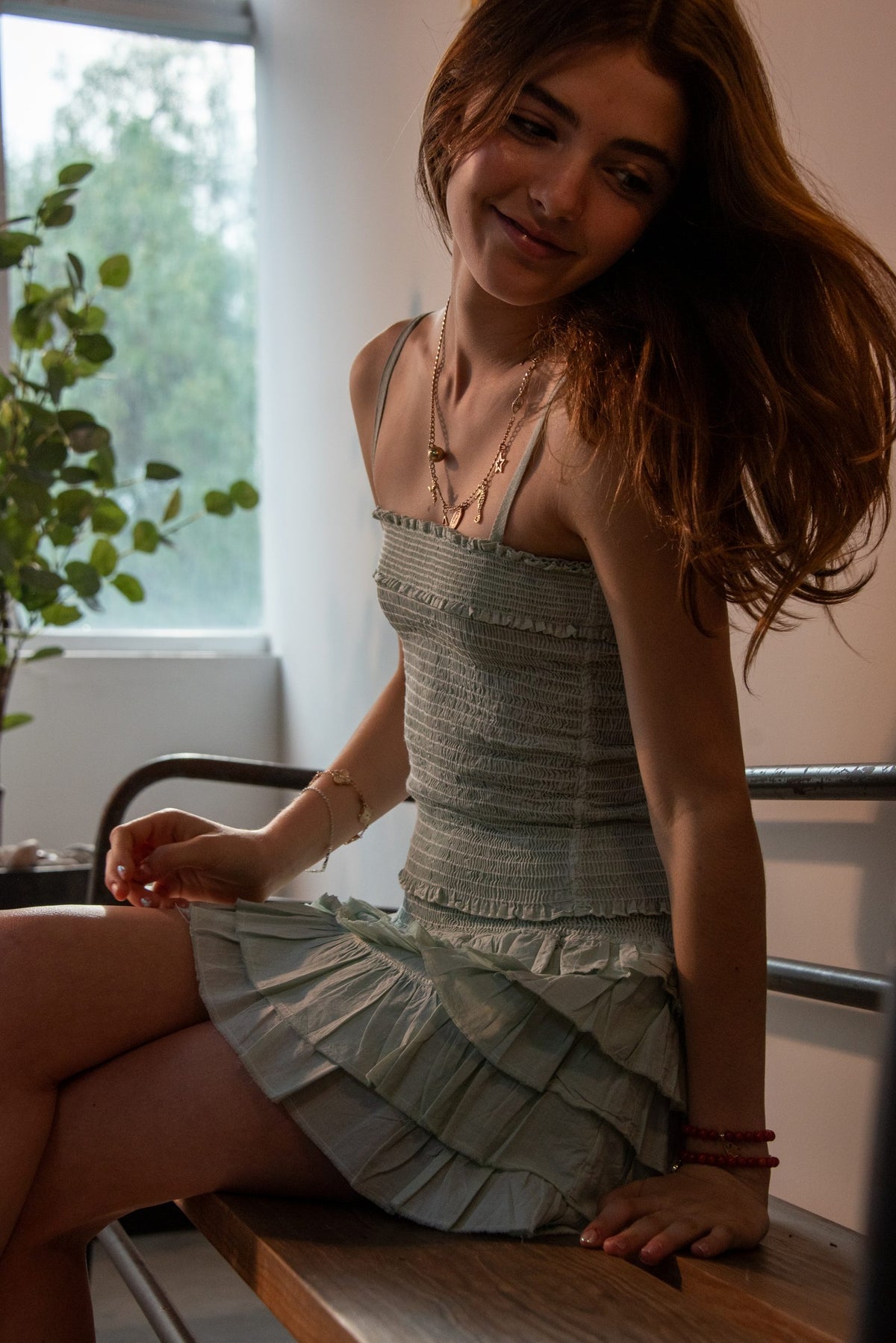 Conjunto verde agua sentado sobre la mesa de madera junto a la ventana — campaña Collabs, Amor Amore