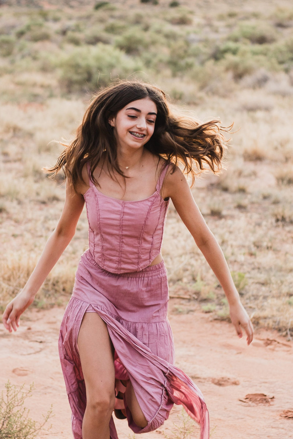 Falda rosa palo con abertura corriendo por el camino de tierra roja — campaña Montaña, Amor Amore