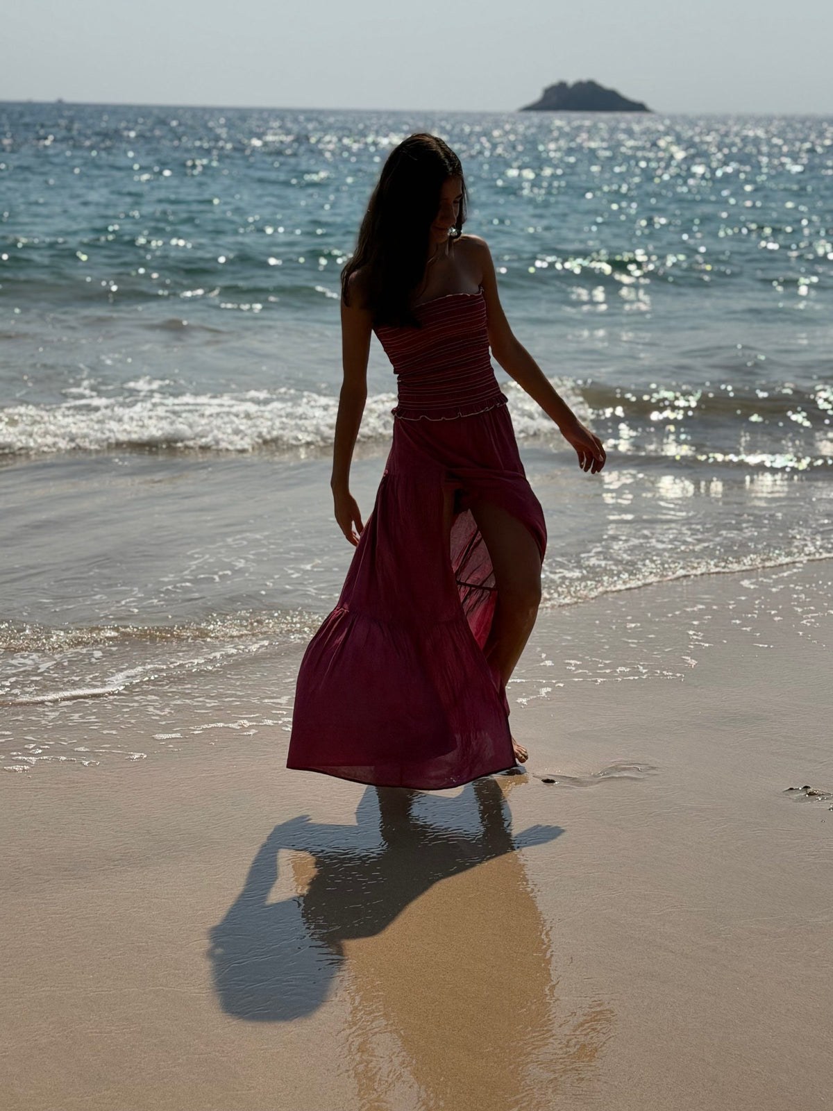 Falda larga vino con abertura de espaldas frente al mar brillante — campaña Playa, Amor Amore